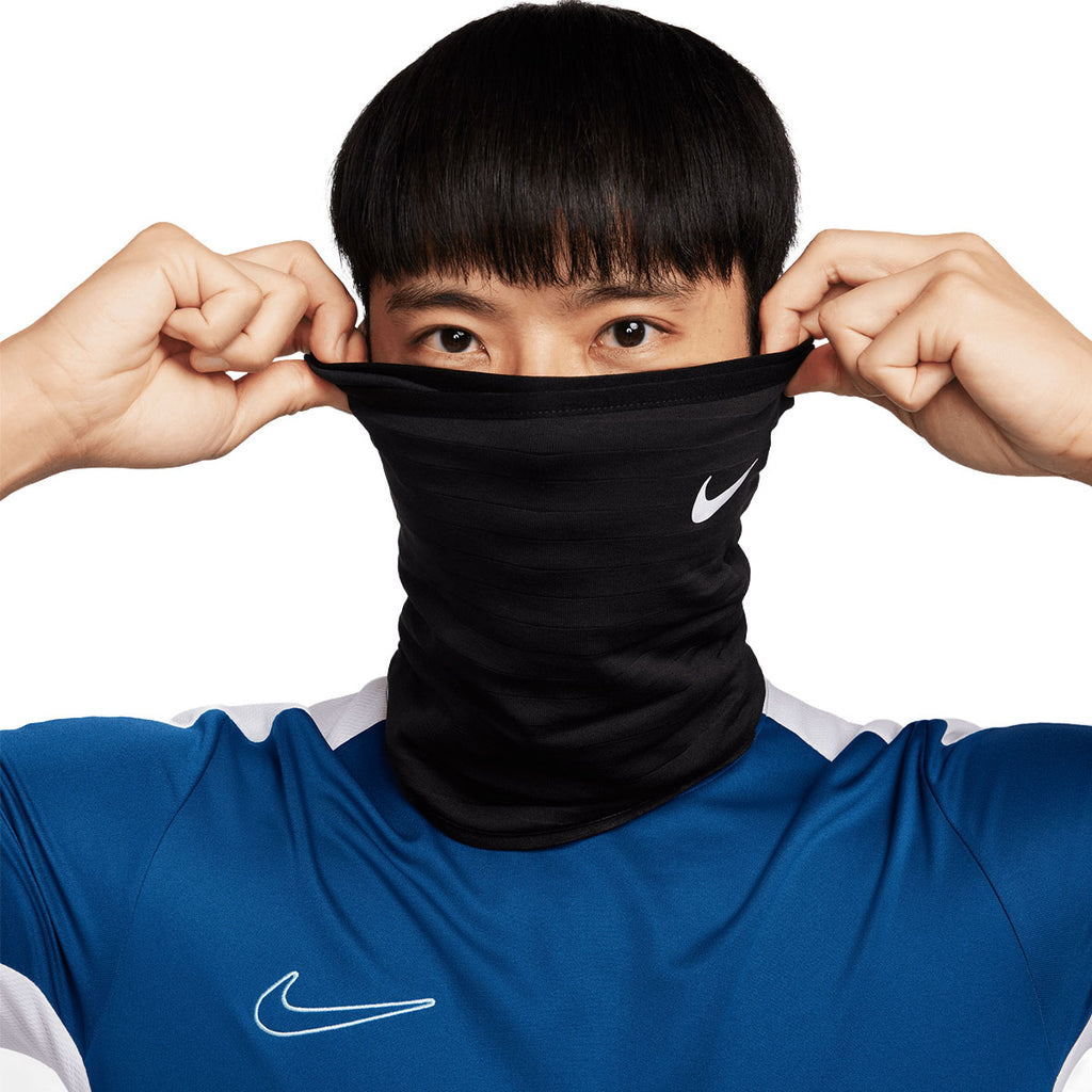 Nike Therma Sphere halsedisse i sort tekstil, holdes foran munden